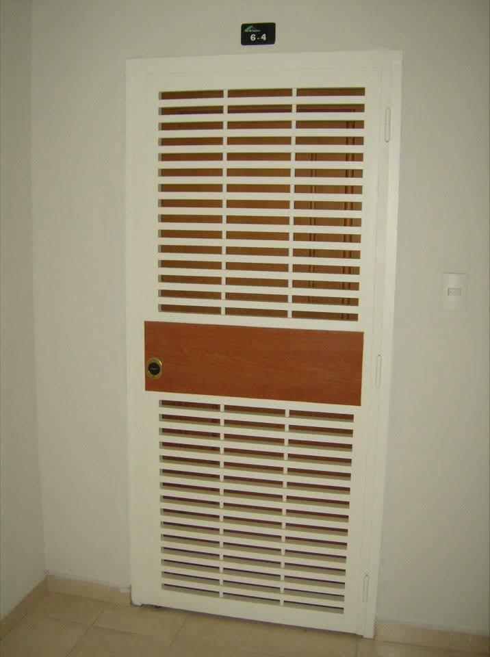 Puerta blanca con celosía horizontal y panel de madera