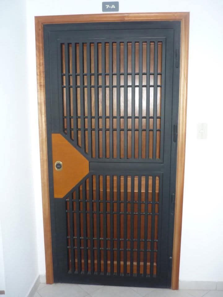 Puerta de seguridad con marco de madera y barrotes negros