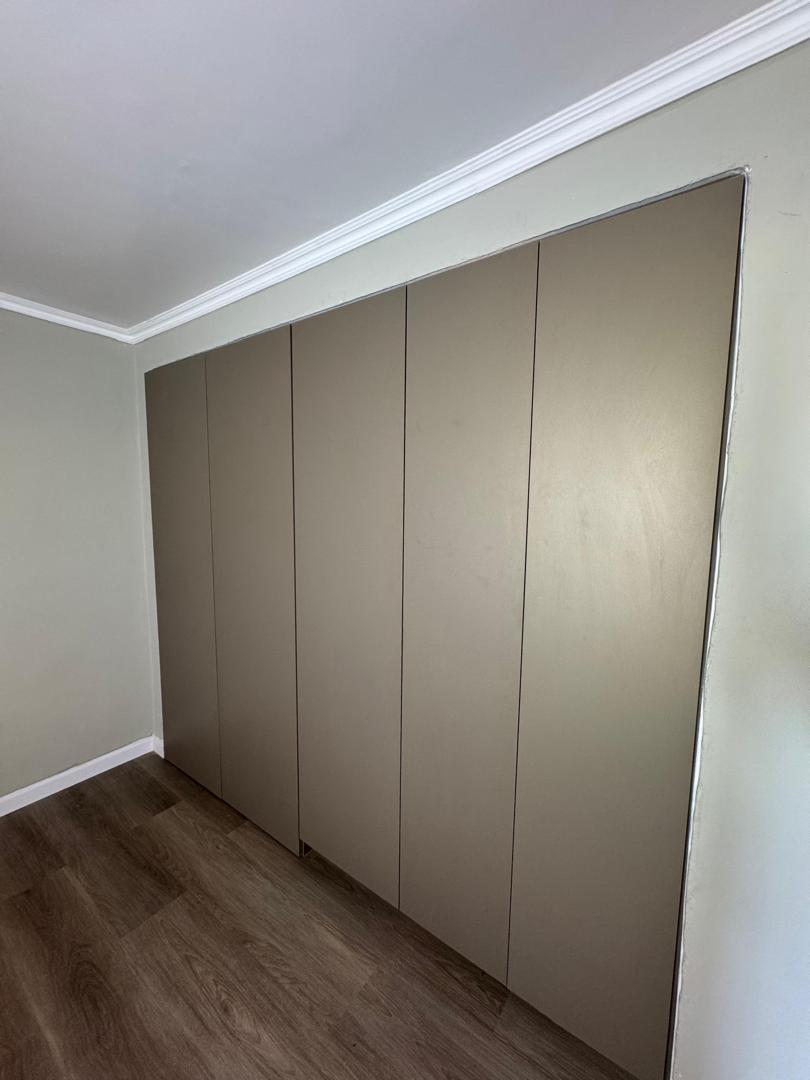 Closet empotrado con frentes lisos en tono arena