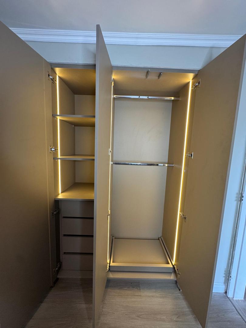 Interior de closet con iluminación LED y barras cromadas