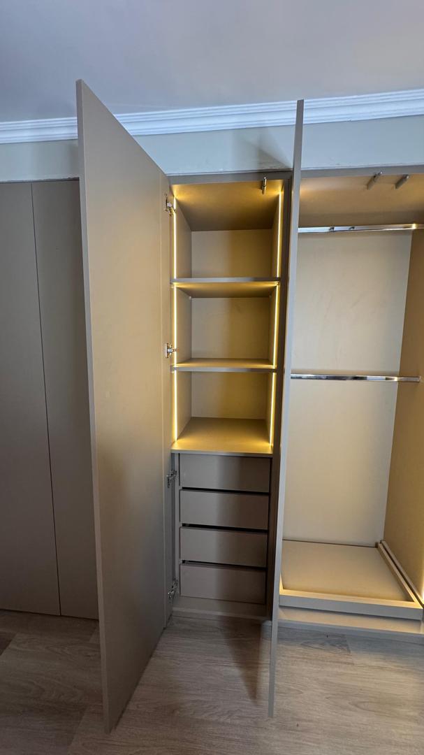 Closet con módulo de gavetas y entrepaños iluminados