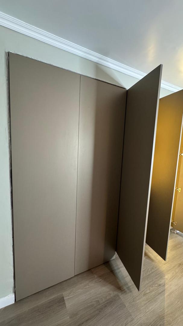 Closet empotrado con puertas batientes en tono visón