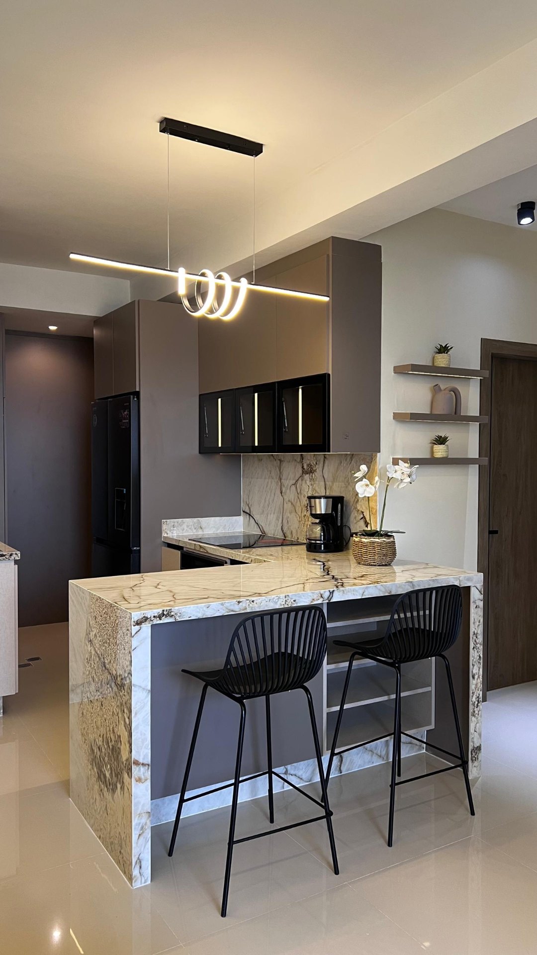 Cocina contemporánea con barra de mármol y lámpara escultural